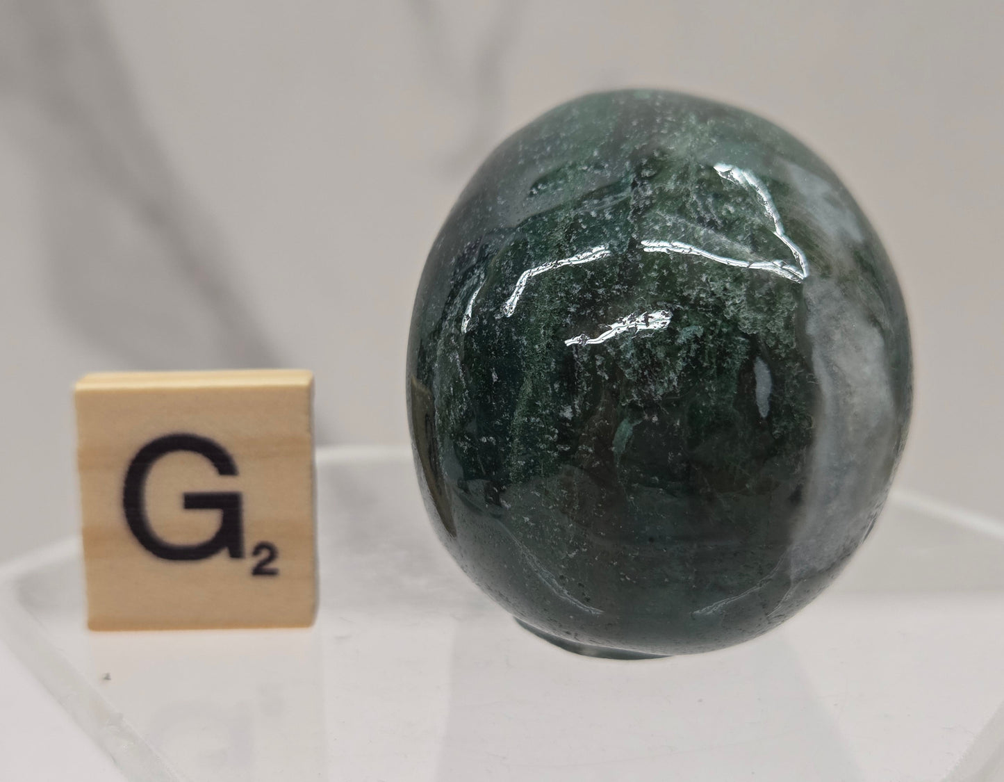 Moss Agate skull carving on a white background