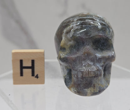 Moss Agate skull carving on a white background