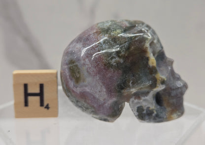 Moss Agate skull carving on a white background