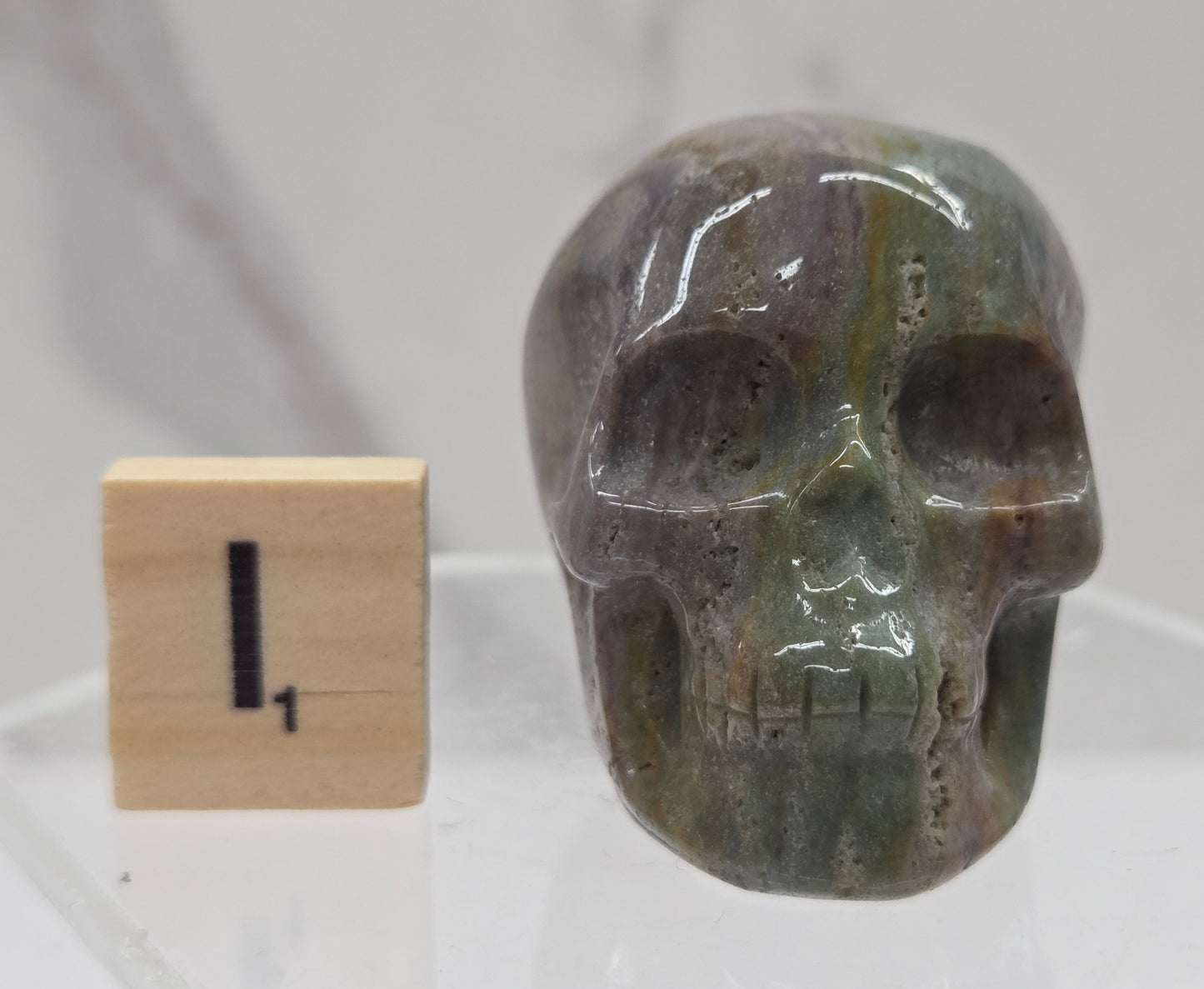 Moss Agate skull carving on a white background