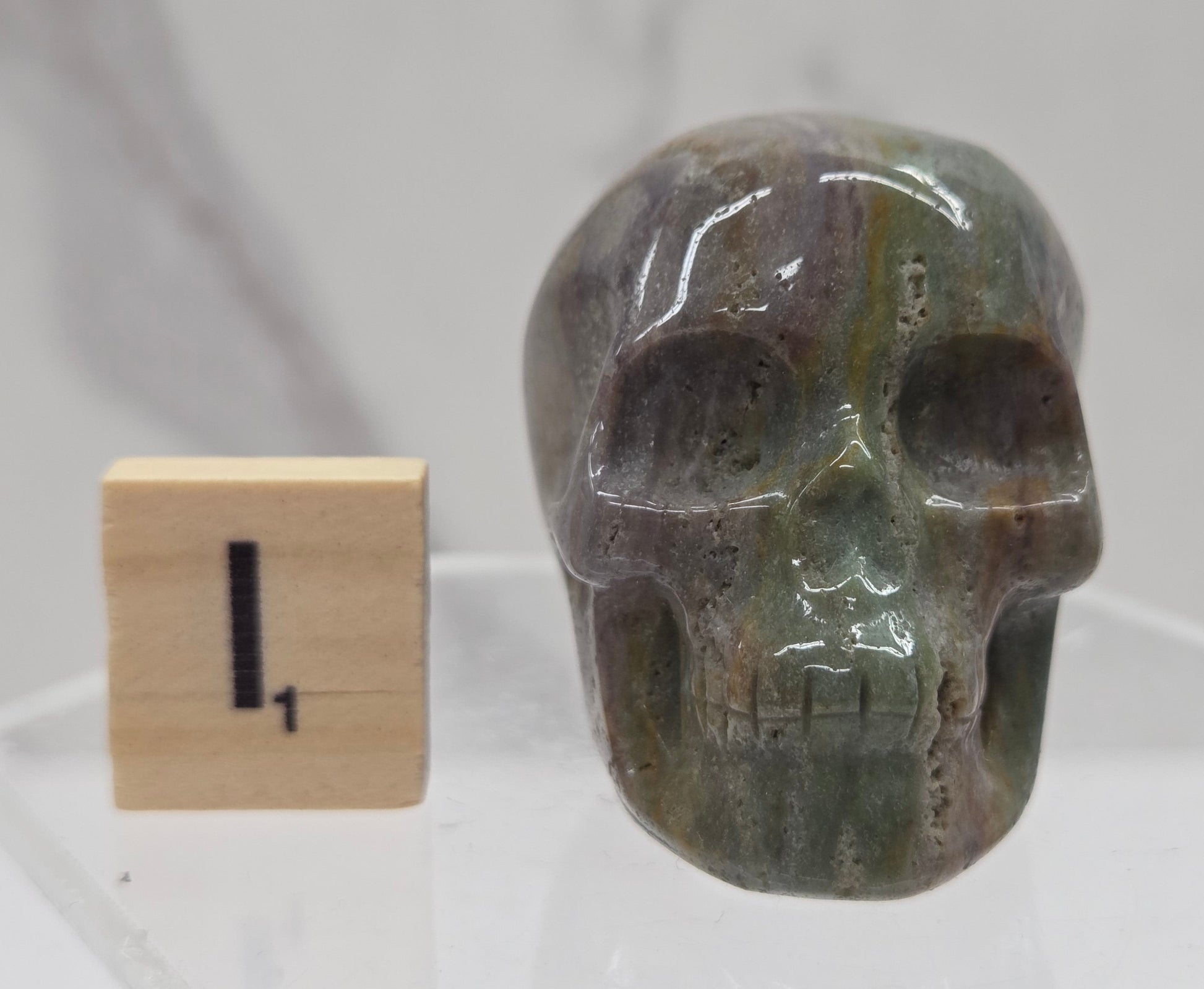 Moss Agate skull carving on a white background