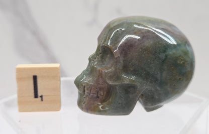 Moss Agate skull carving on a white background