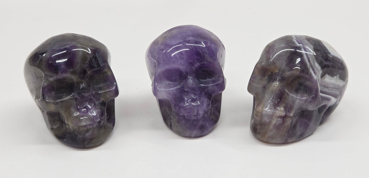collection of amethyst skulls on a white background