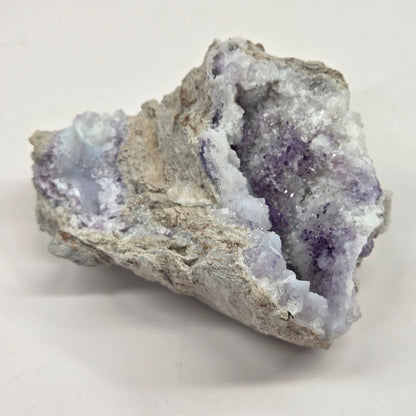 Mineral geode with white and purple coloring against a white background