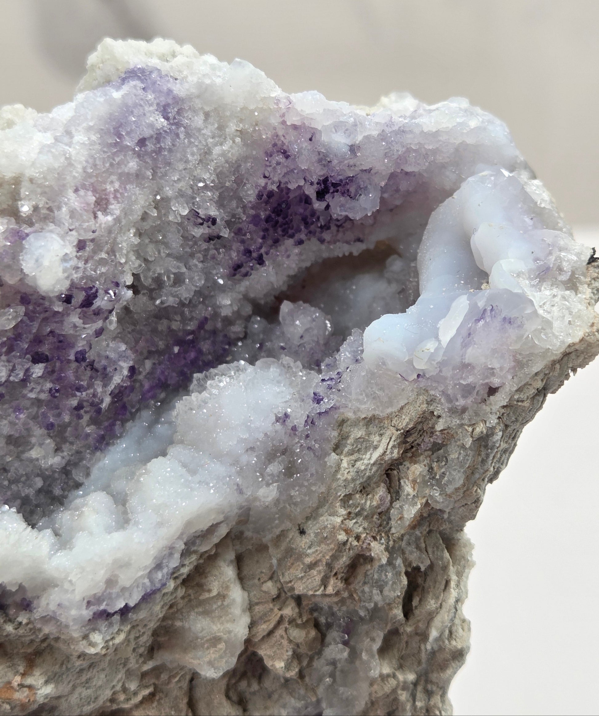 Close-up of a Mineral geode with white and purple coloring against a white background