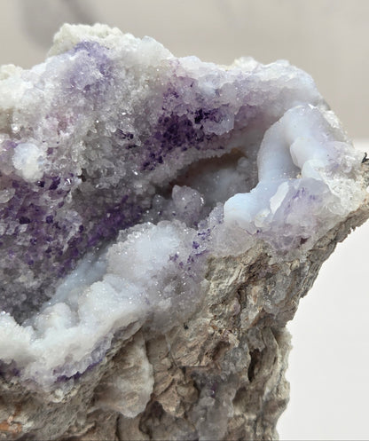 Close-up of a Mineral geode with white and purple coloring against a white background