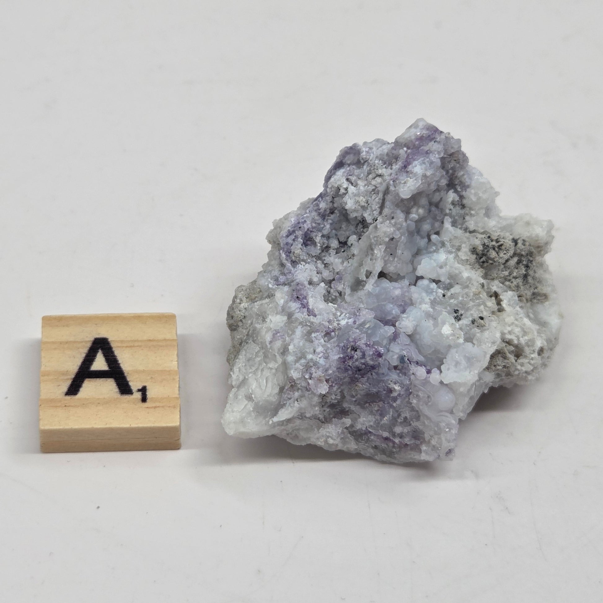 Mineral geode with white and purple coloring against a white background