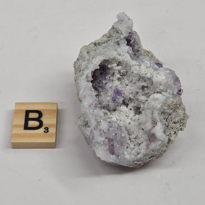 Mineral geode with white and purple coloring against a white background