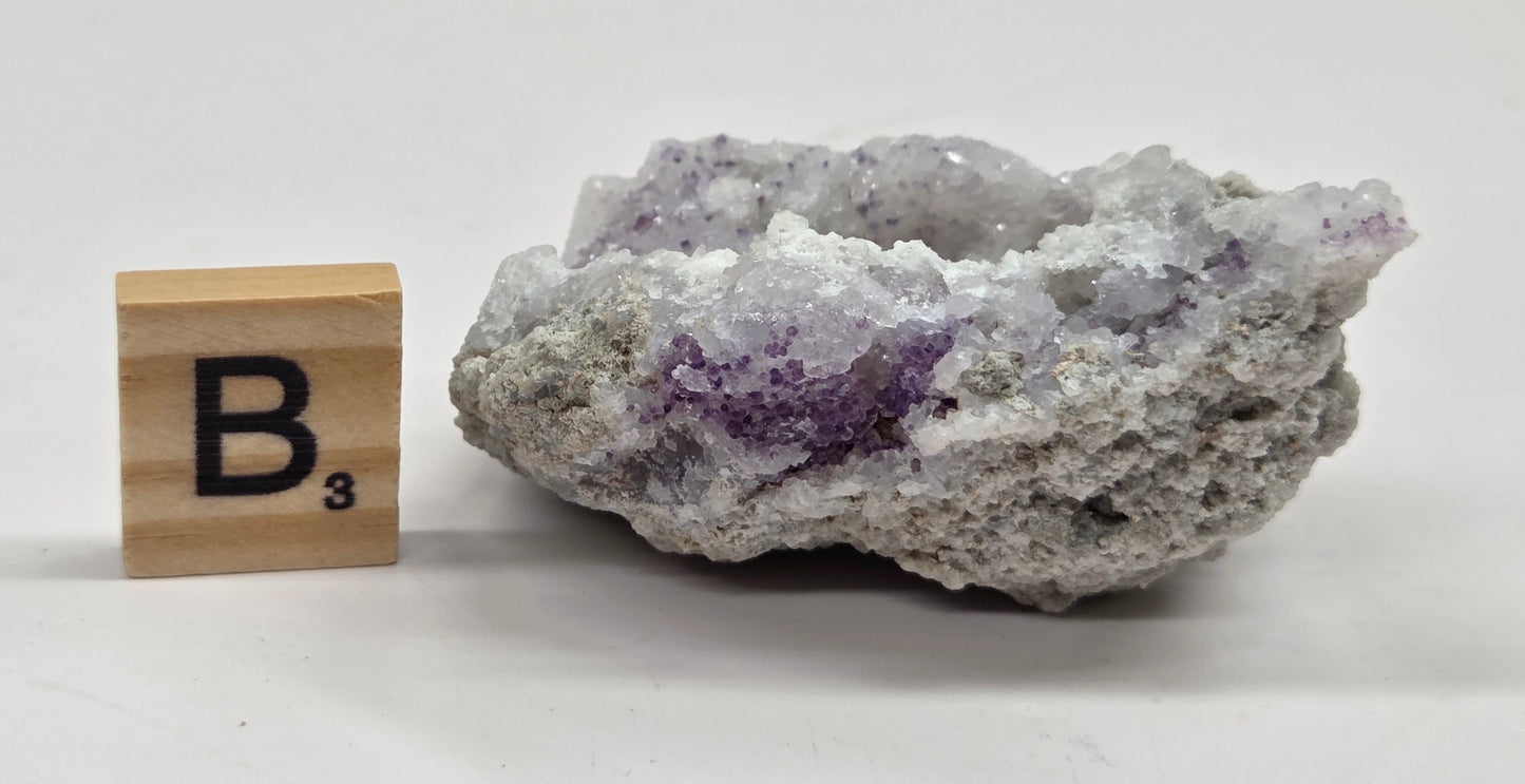 Mineral geode with white and purple coloring against a white background