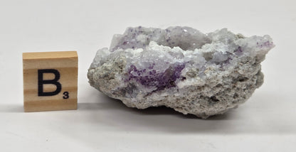 Mineral geode with white and purple coloring against a white background