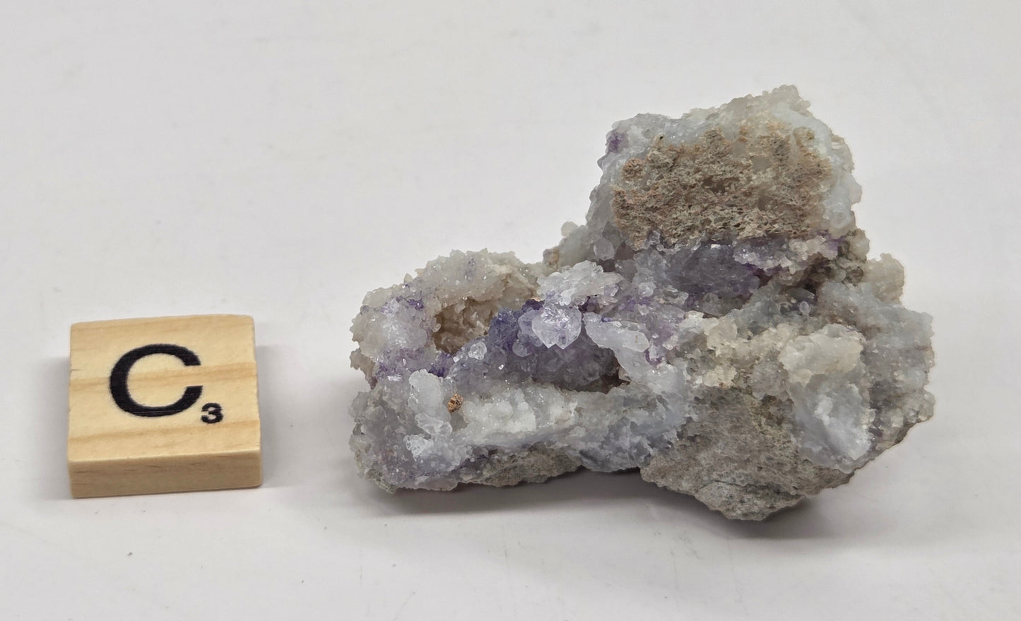 Mineral geode with white and purple coloring against a white background