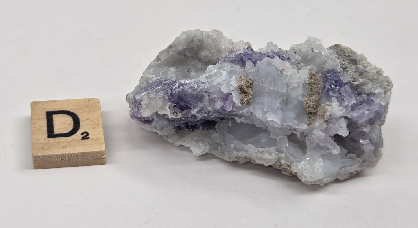 Mineral geode with white and purple coloring against a white background