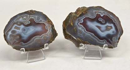 Mineral slab with grey and red coloring and banding on acrylic chairs against a white background