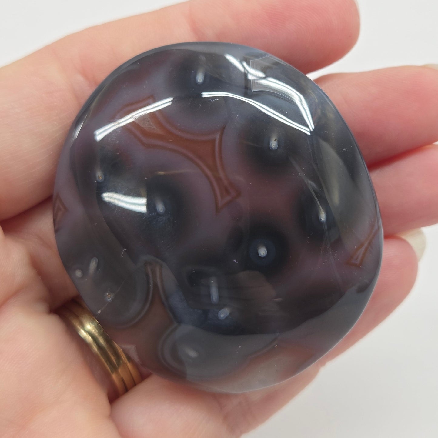 Agate free form with grey and red coloring and banding against a white background
