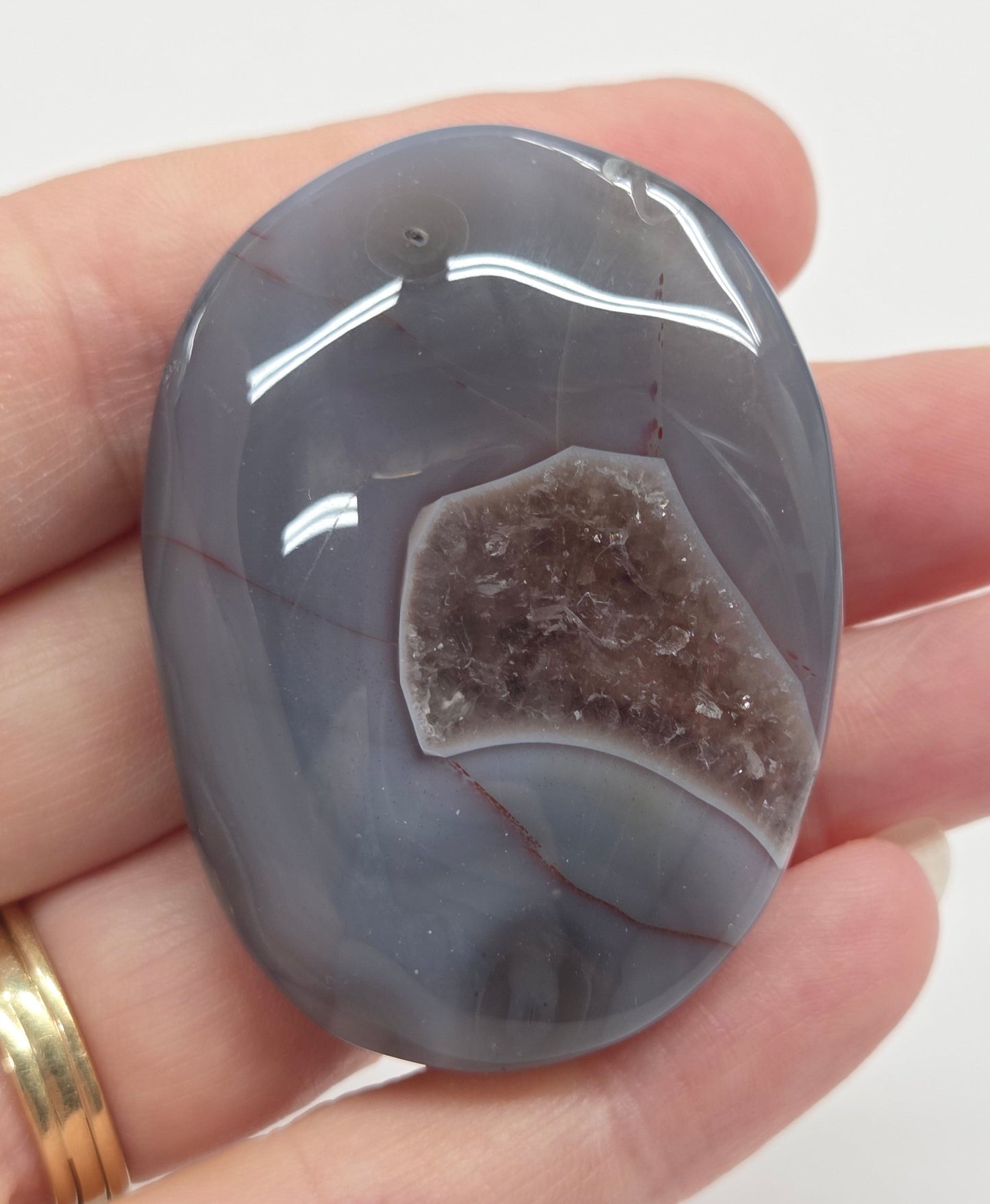 Agate free form with grey and red coloring and banding against a white background