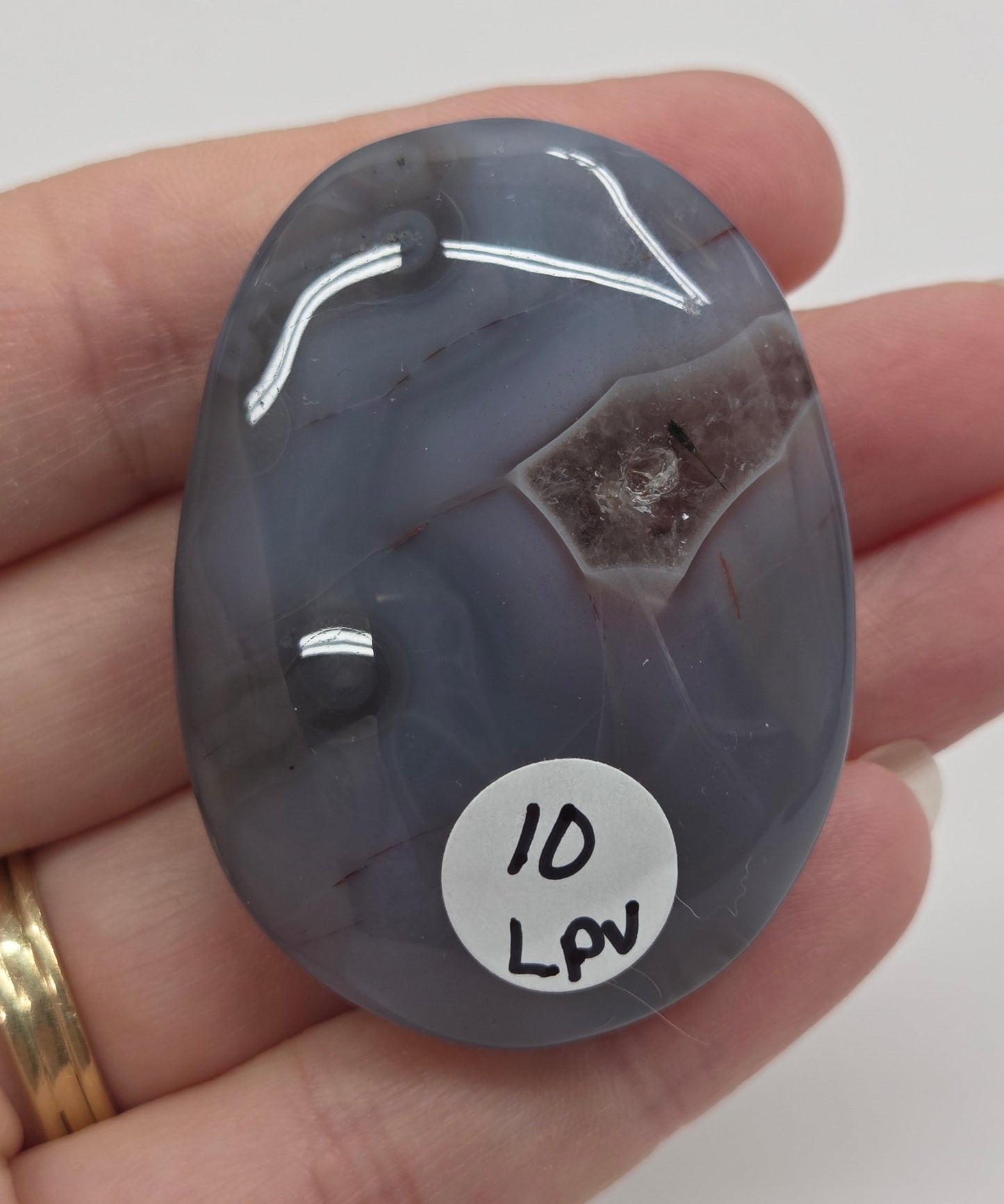 Agate free form with grey and red coloring and banding against a white background