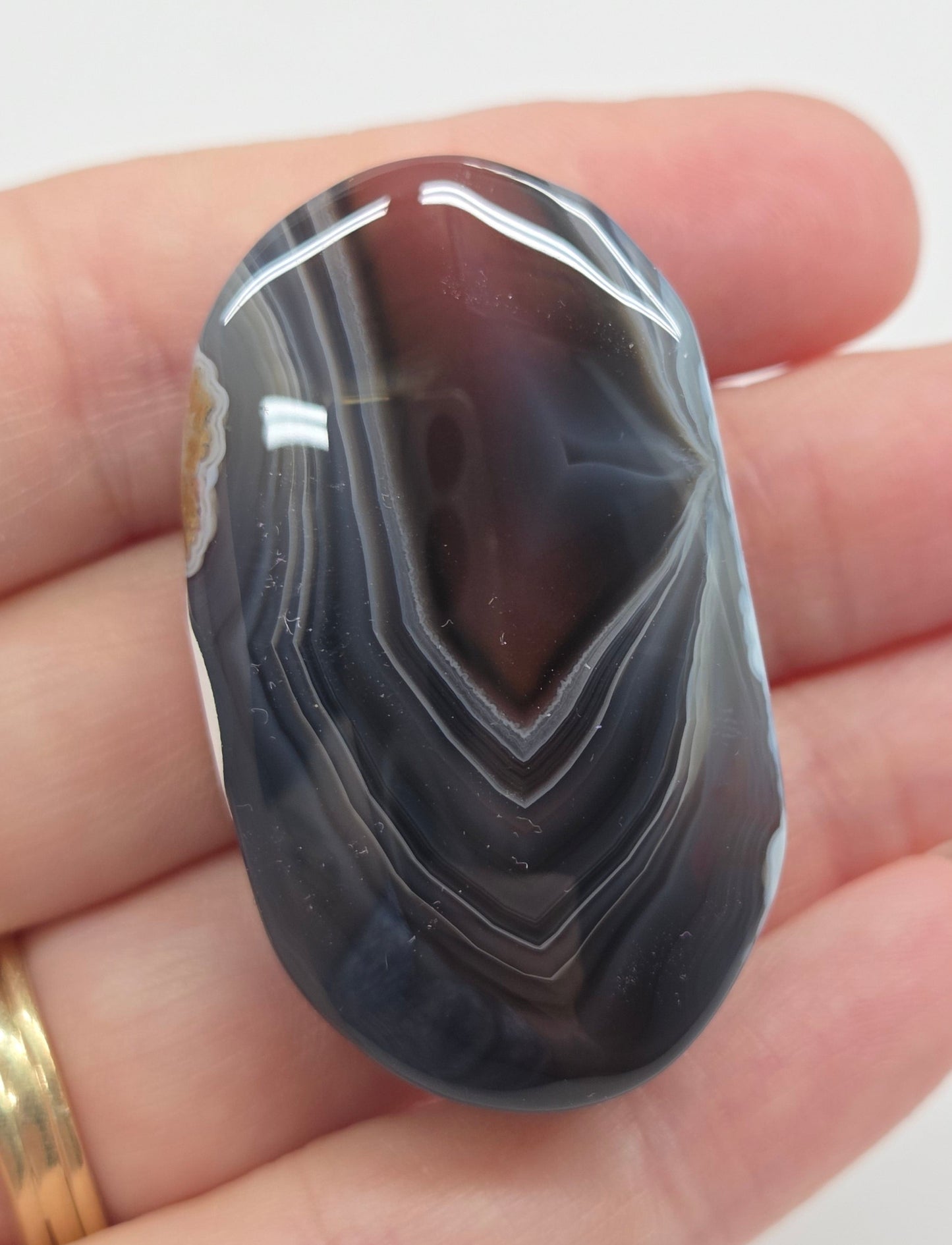 Agate free form with grey and red coloring and banding against a white background