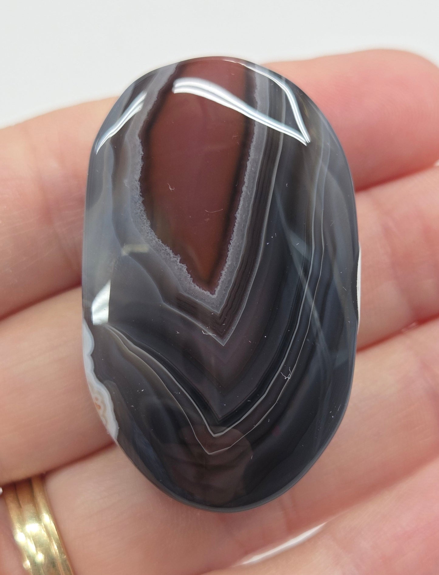 Agate free form with grey and red coloring and banding against a white background