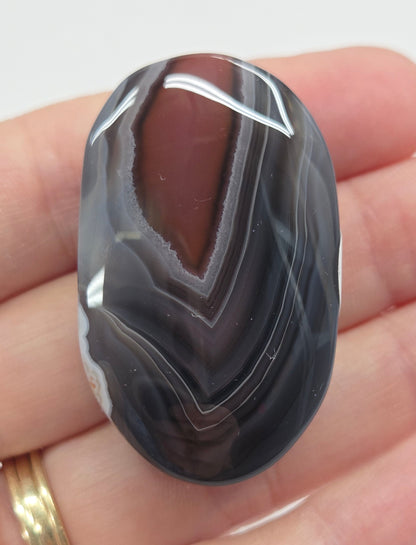 Agate free form with grey and red coloring and banding against a white background