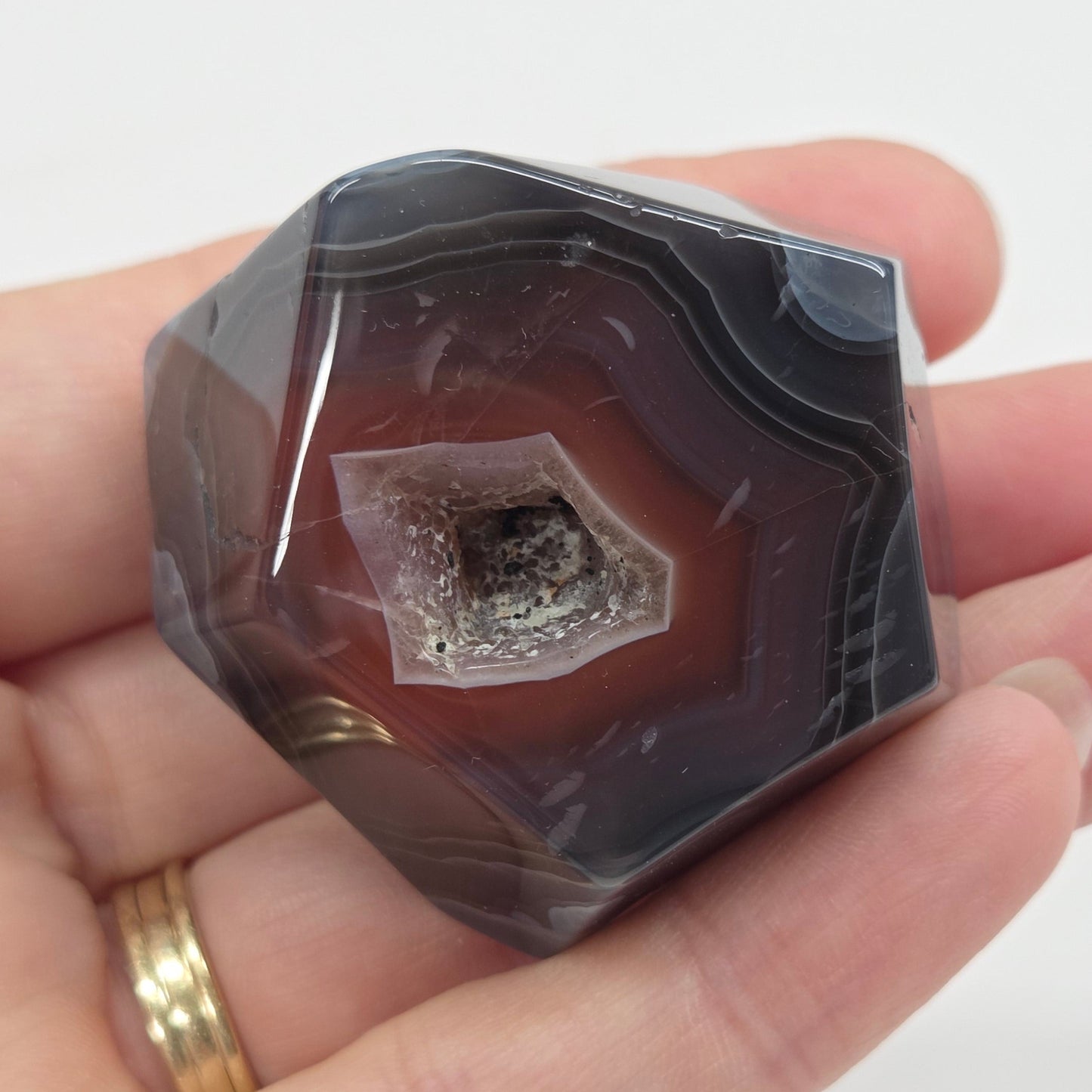 Agate free form with grey and red coloring and banding against a white background