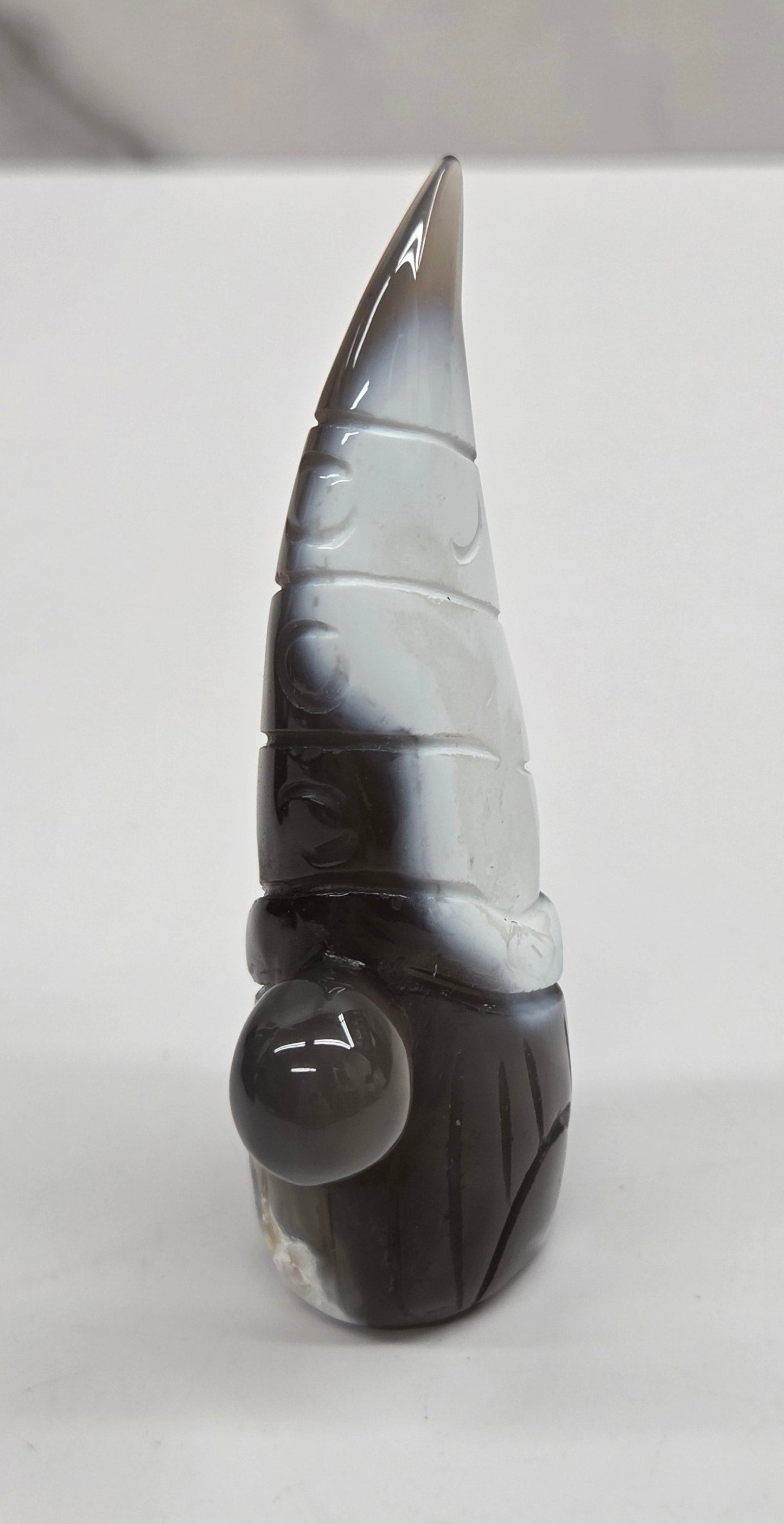 Black and white agate gnome shaped carving on a white background