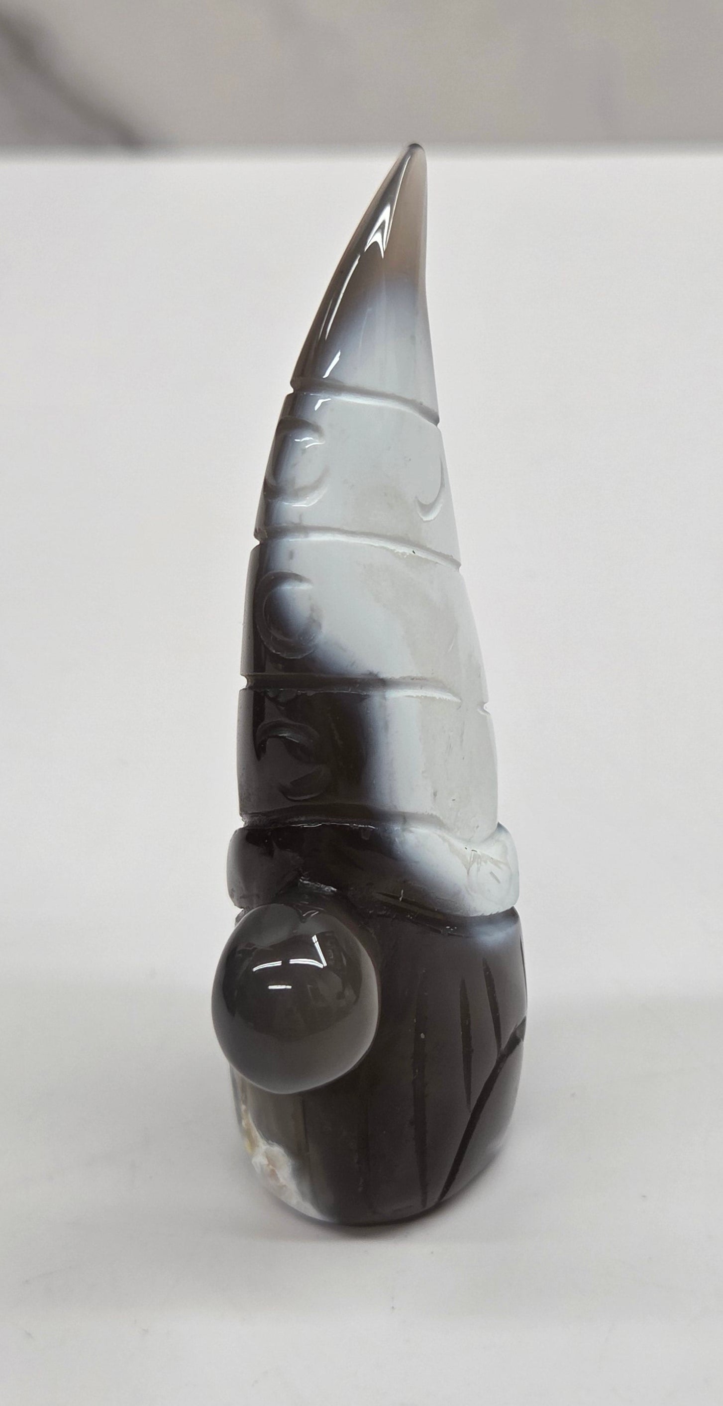 Black and white agate gnome shaped carving on a white background