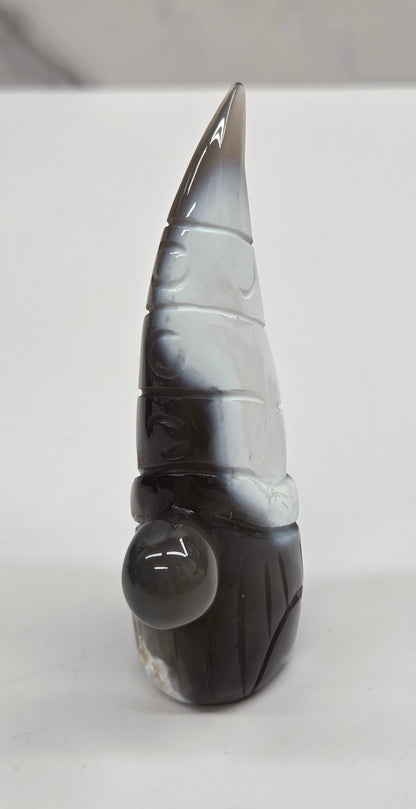 Black and white agate gnome shaped carving on a white background