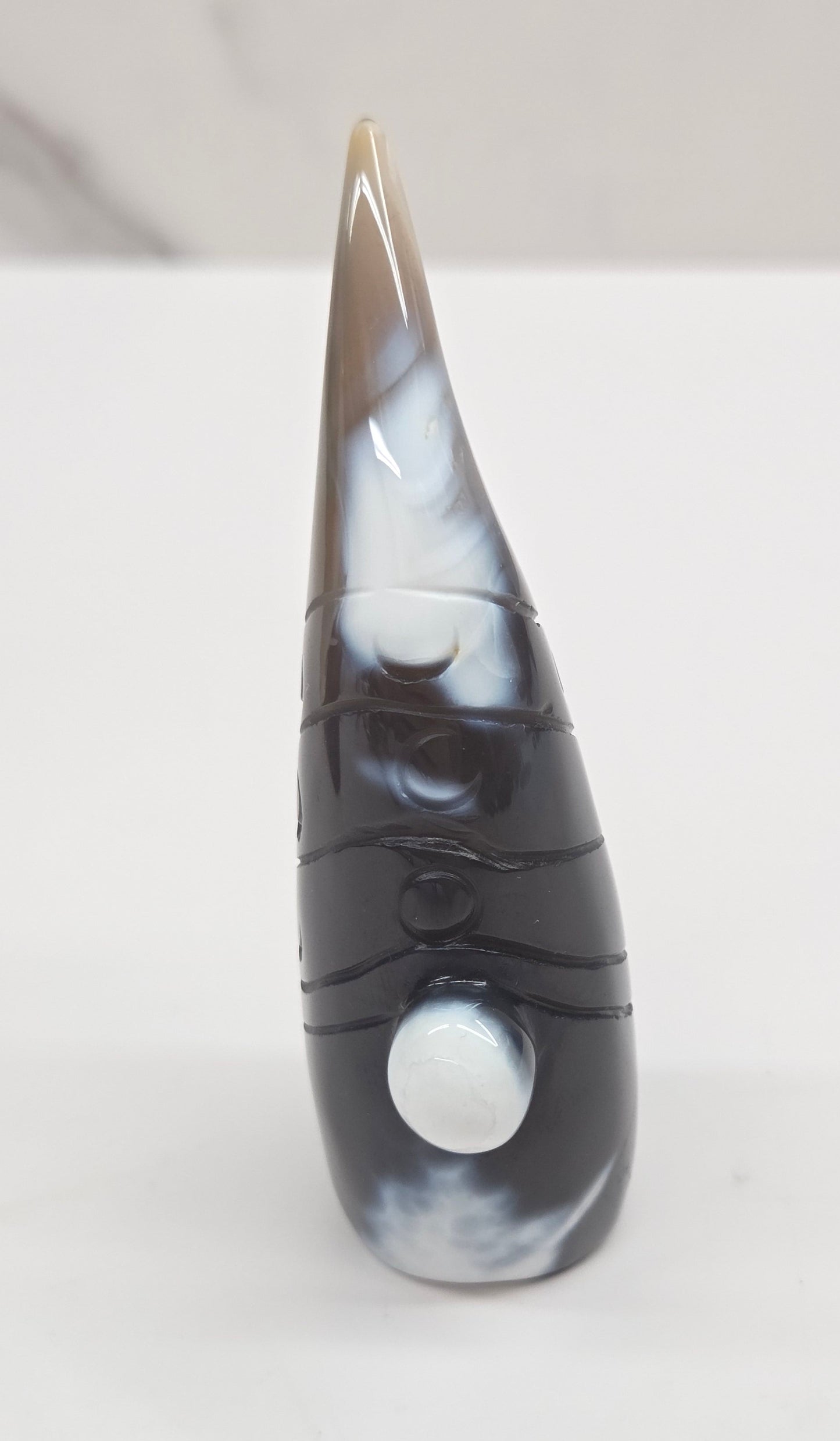 Black and white agate gnome shaped carving on a white background