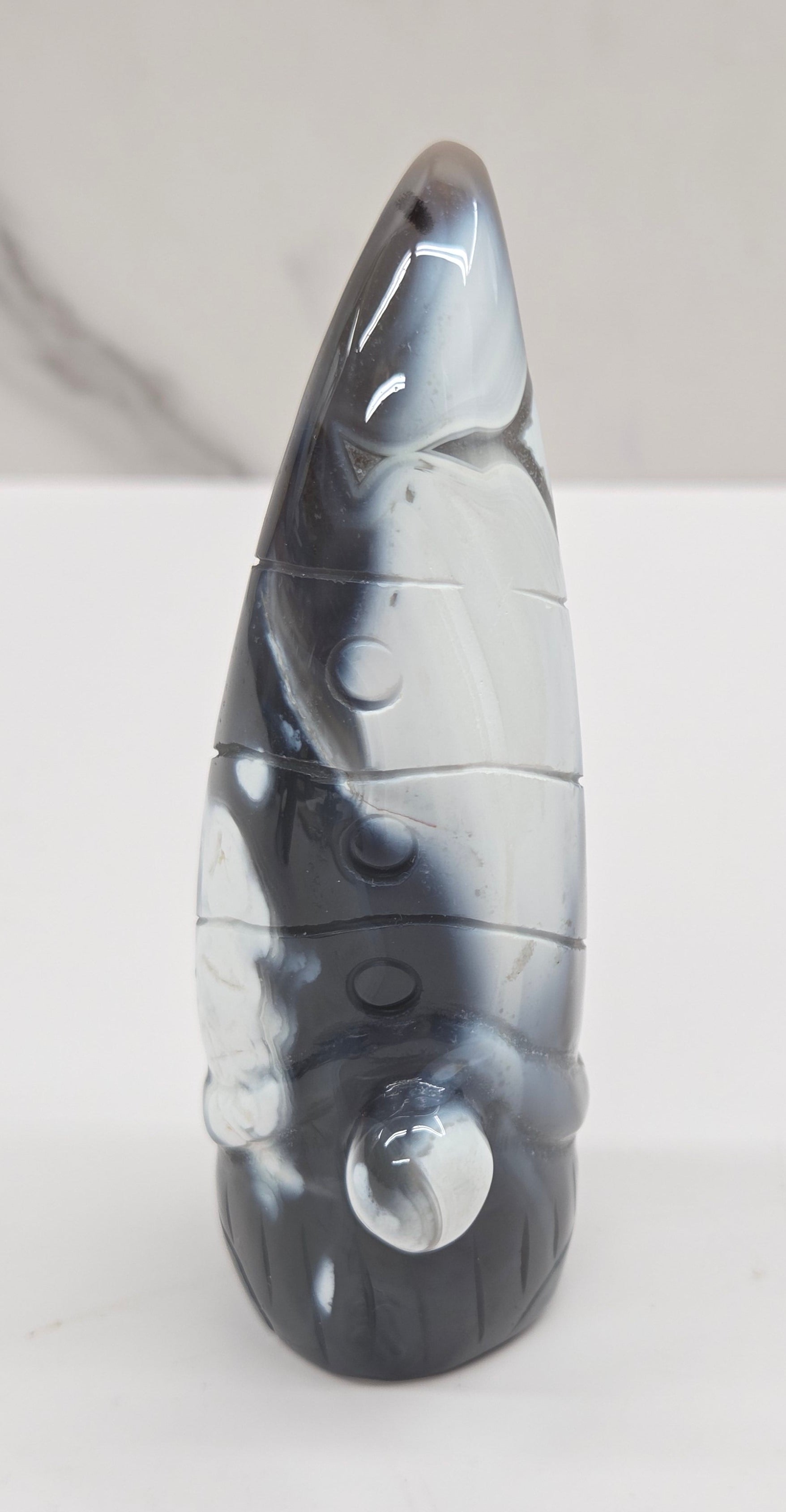 Black and white agate gnome shaped carving on a white background