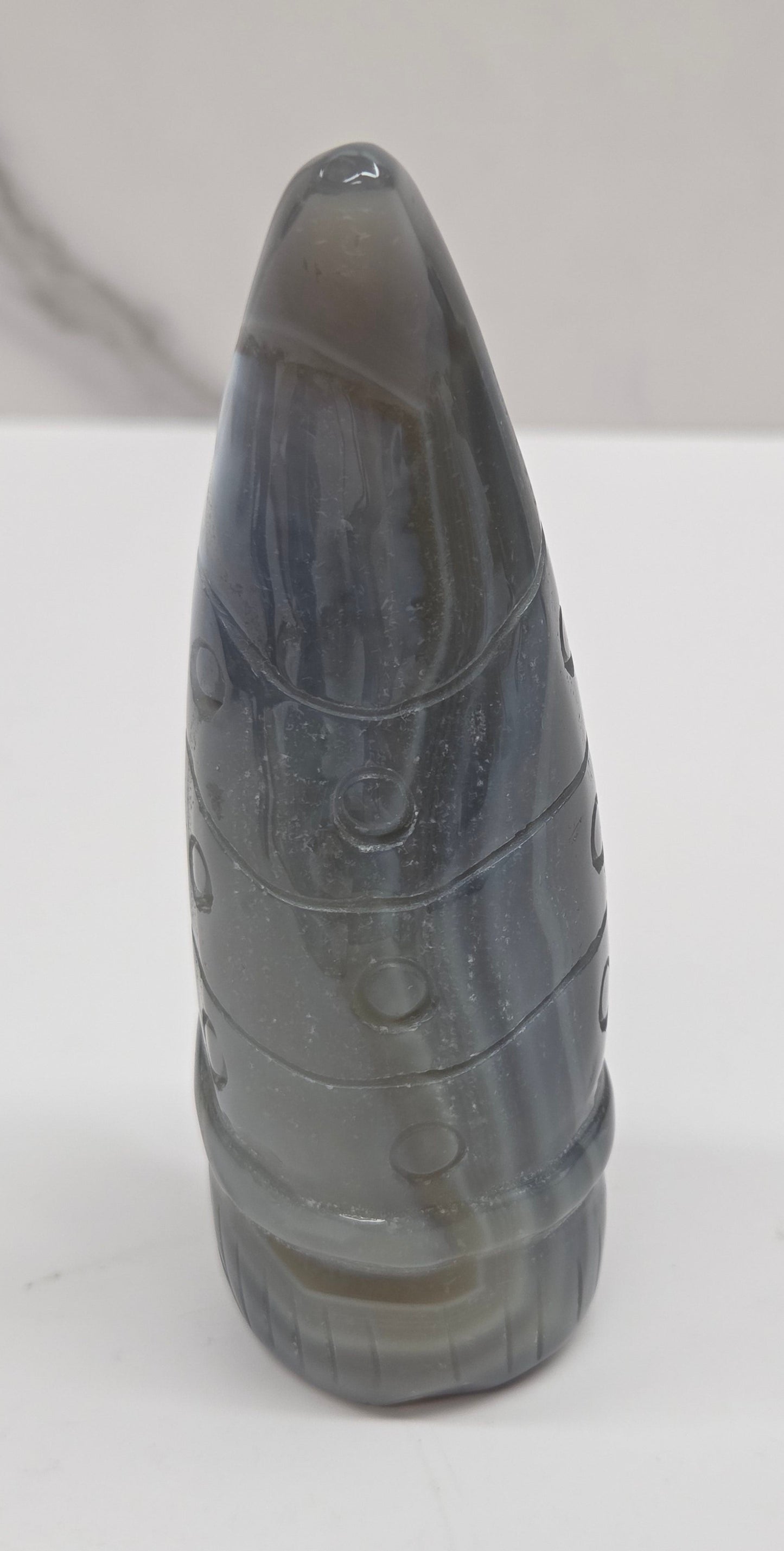 Black and white agate gnome shaped carving on a white background