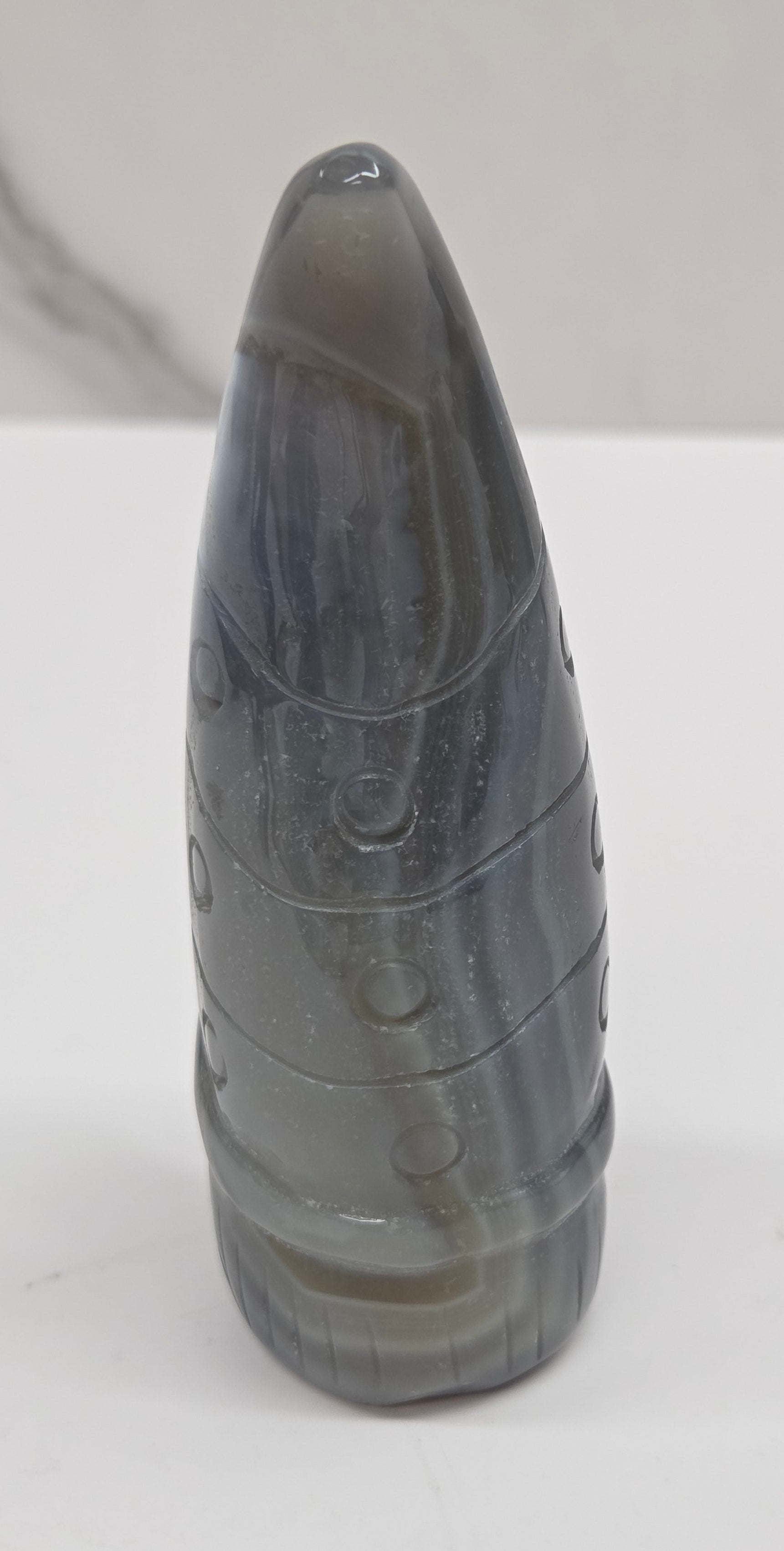Black and white agate gnome shaped carving on a white background