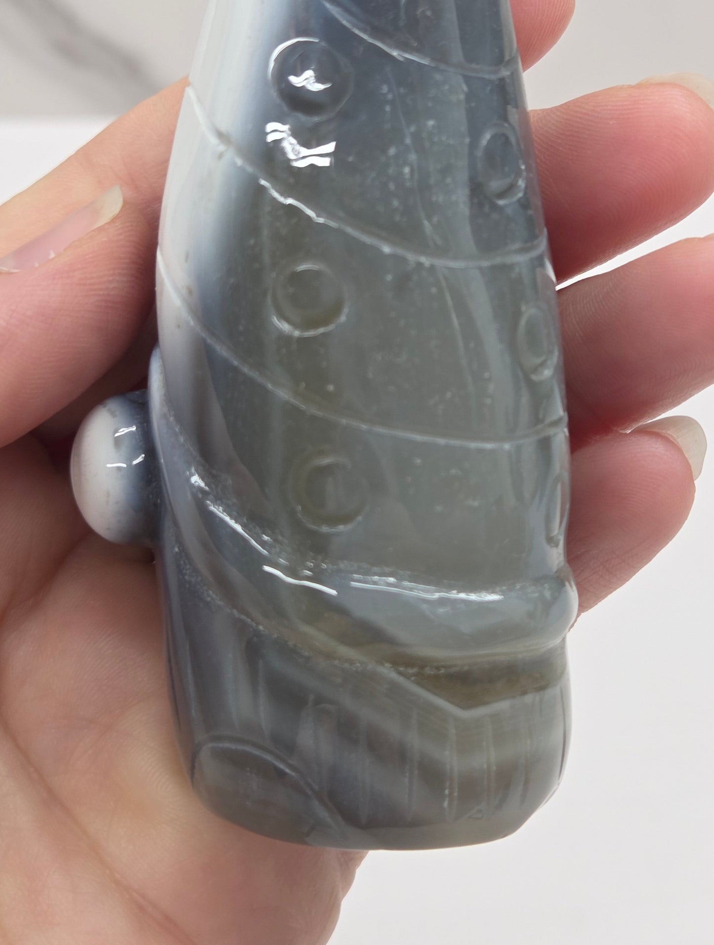 Black and white agate gnome shaped carving on a white background