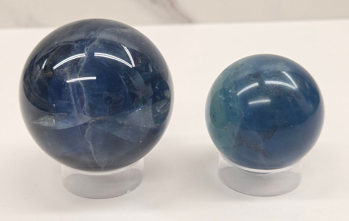 Blue Fluorite spheres on acrylic holders against a white background