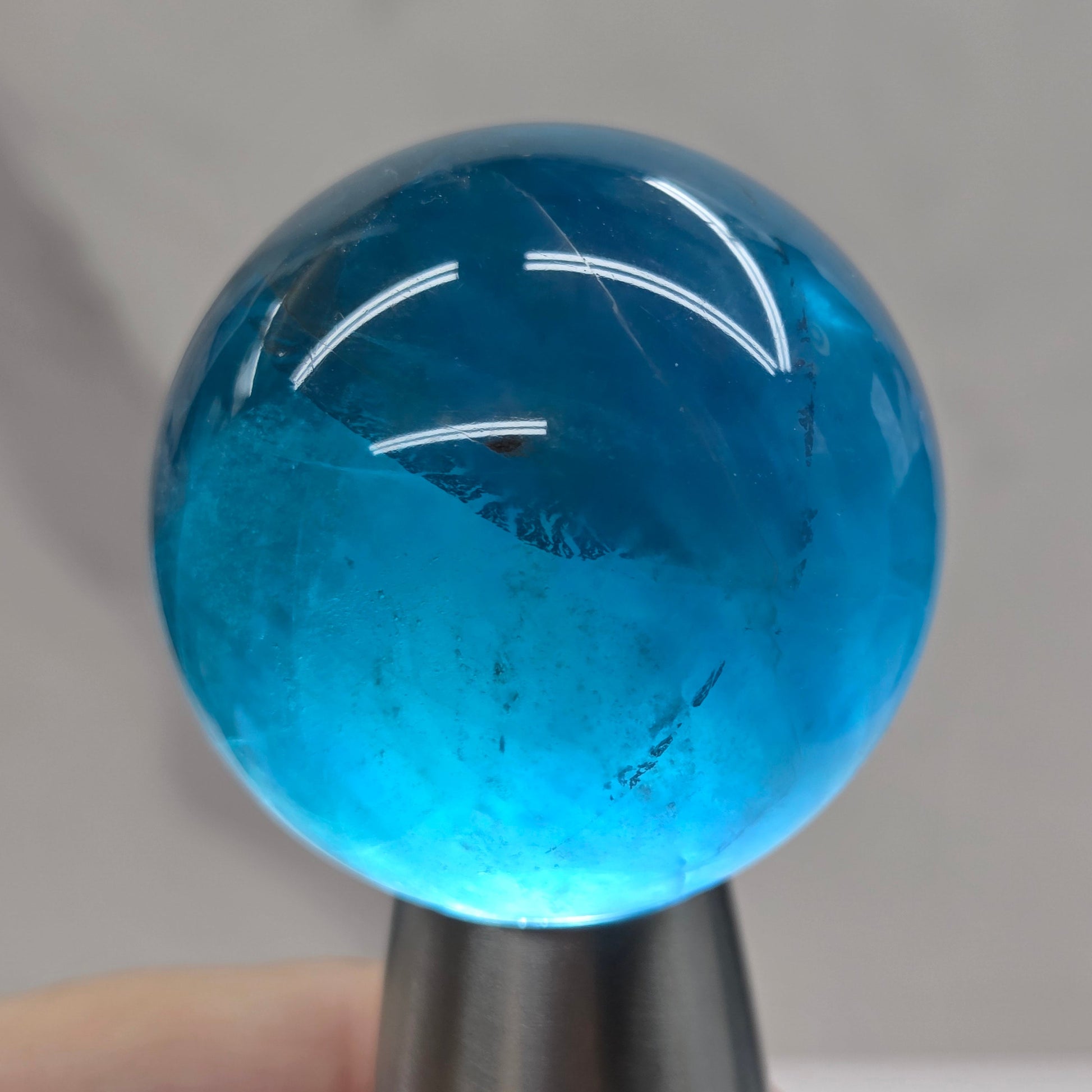 Blue fluorite sphere with a backlight against a white background