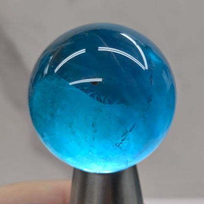 Blue fluorite sphere with a backlight against a white background