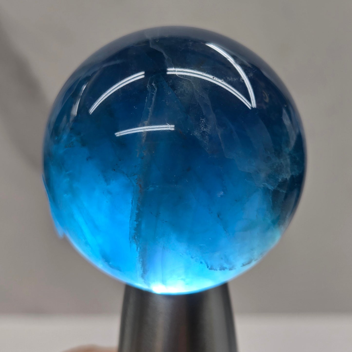 Blue fluorite sphere with a backlight against a white background