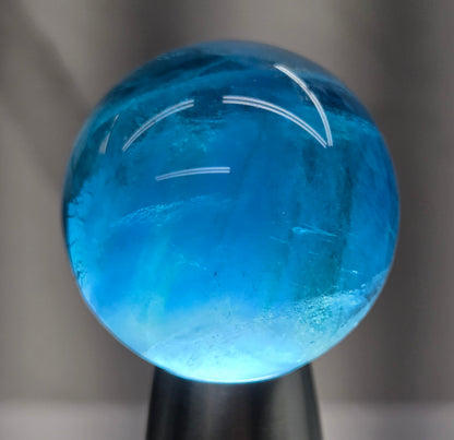 Blue fluorite sphere with a backlight against a white background