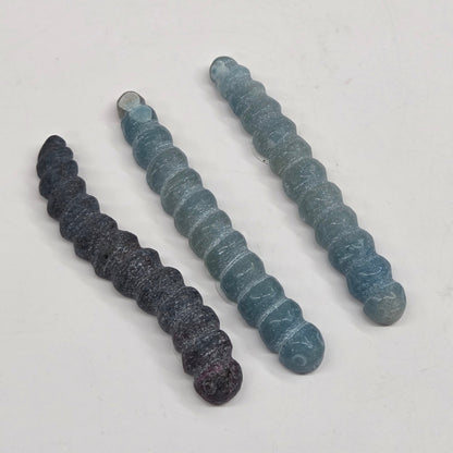 Blue crystal worm carvings on a white background