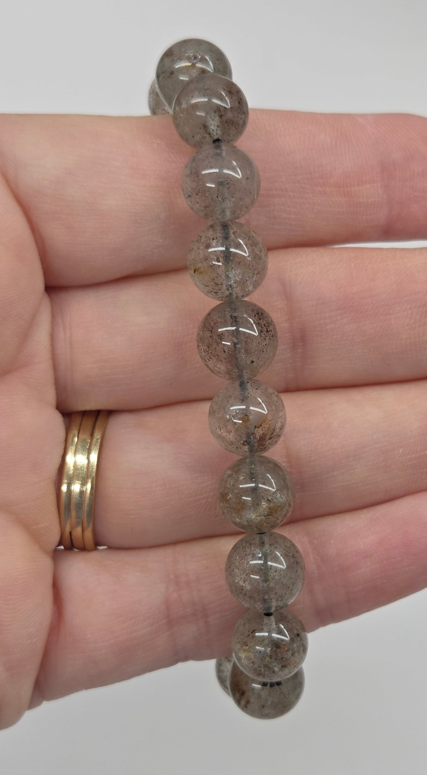 Beaded bracelet with inclusions being held in a hand