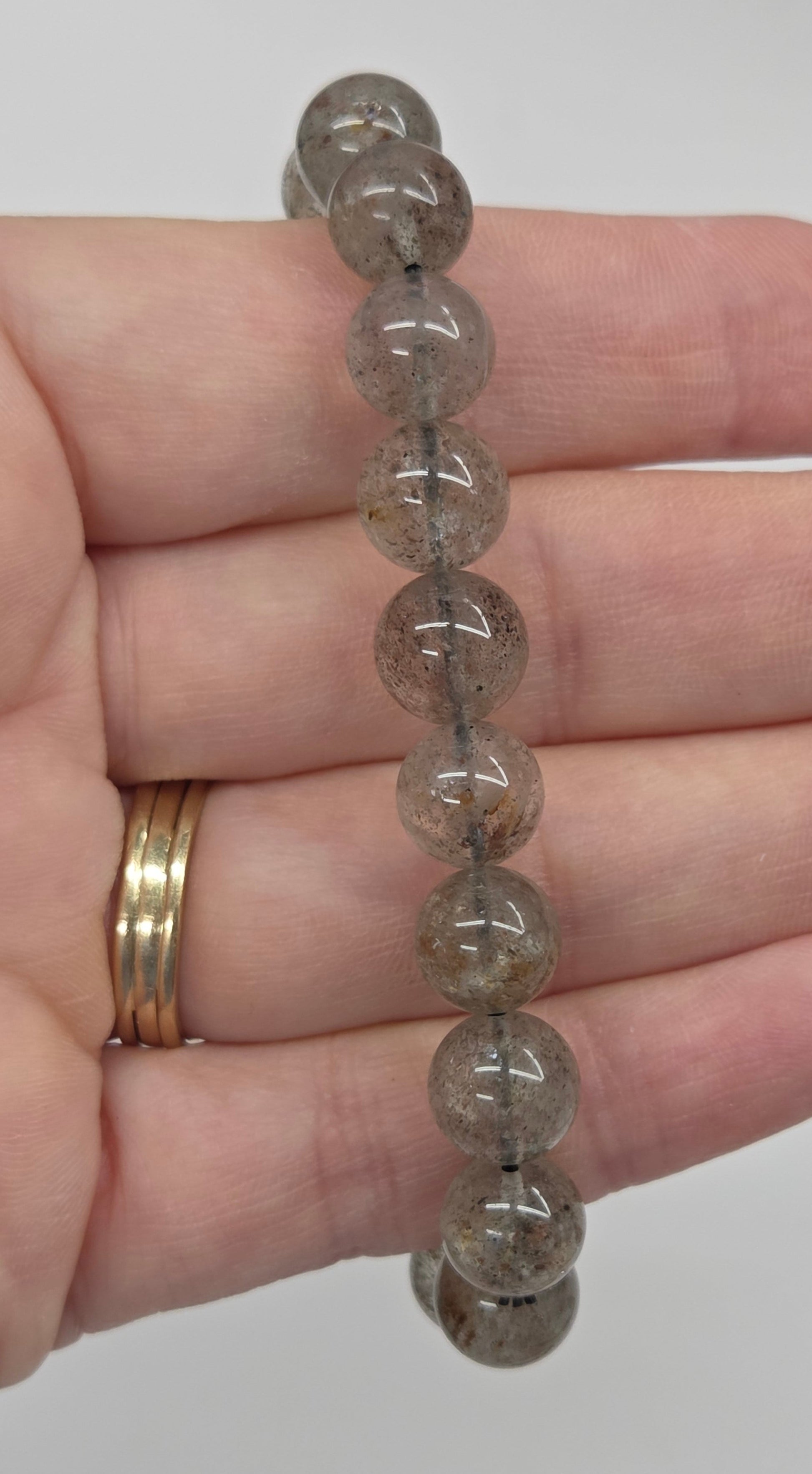 Beaded bracelet with inclusions being held in a hand