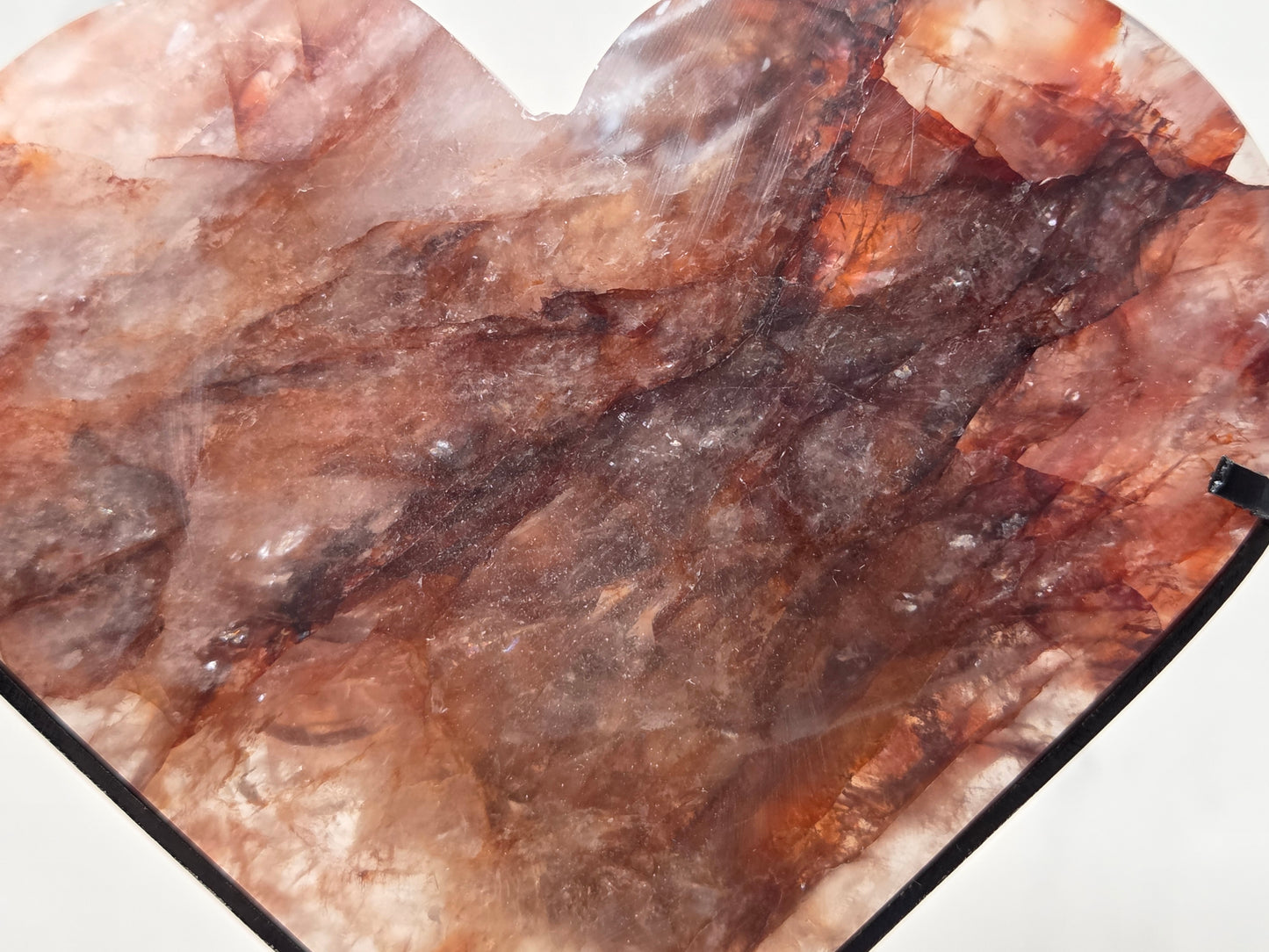 A heart-shaped stone piece with a natural quartz-like texture in shades of brown, beige, and translucent tones, shown against a plain white background.