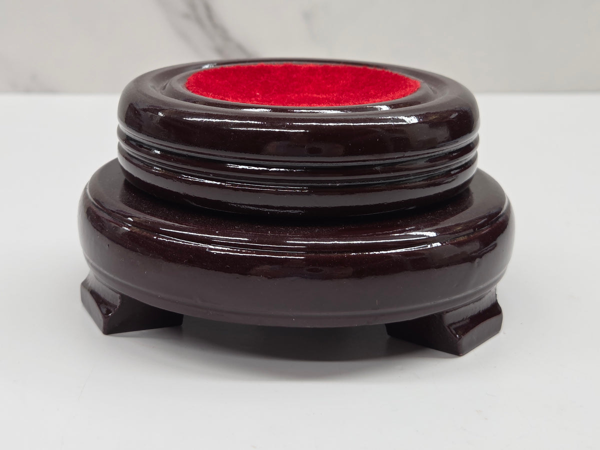 Round wood sphere holder with red velvet on a neutral background