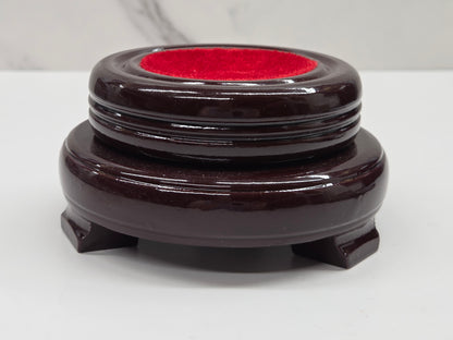 Round wood sphere holder with red velvet on a neutral background