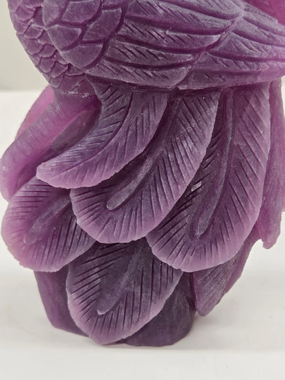 Close up of a purple lepidolite phoenix carving on a white background