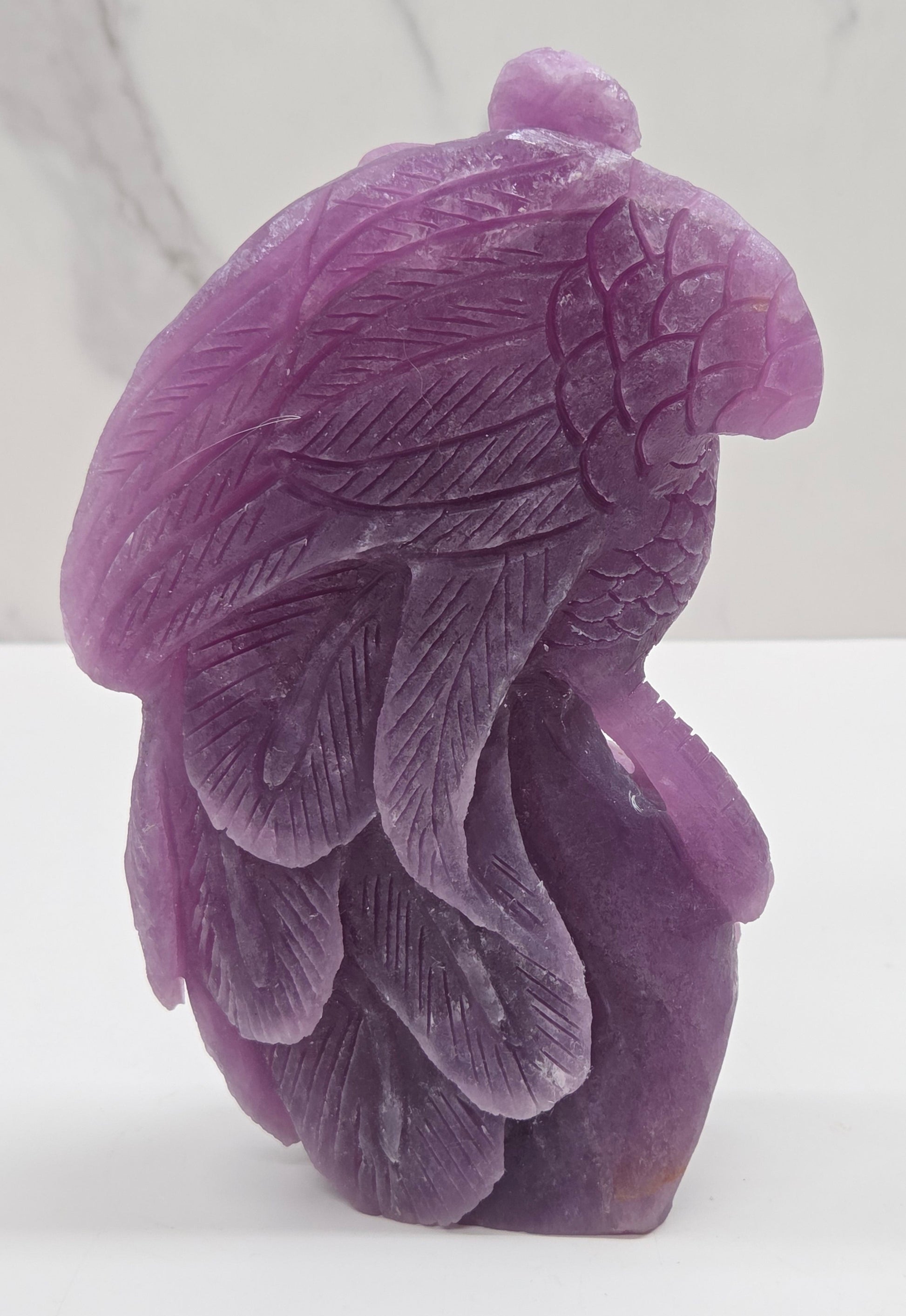 Purple lepidolite phoenix carving on a white background