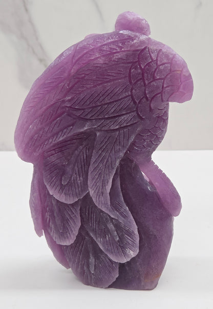 Purple lepidolite phoenix carving on a white background