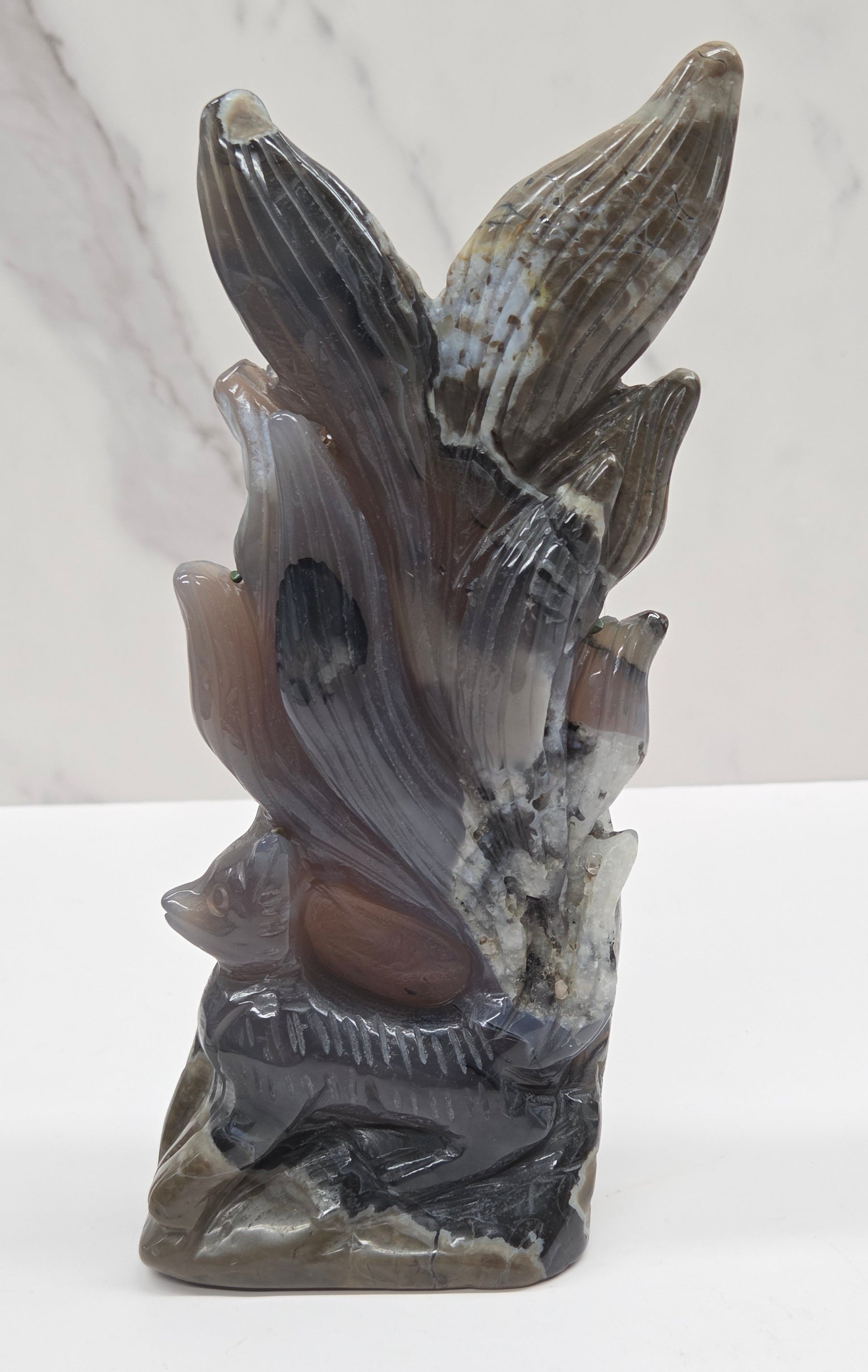 Volcano Agate carving of a nine tail fox against a white background