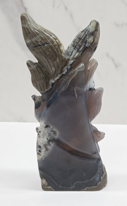 Volcano Agate carving of a nine tail fox against a white background