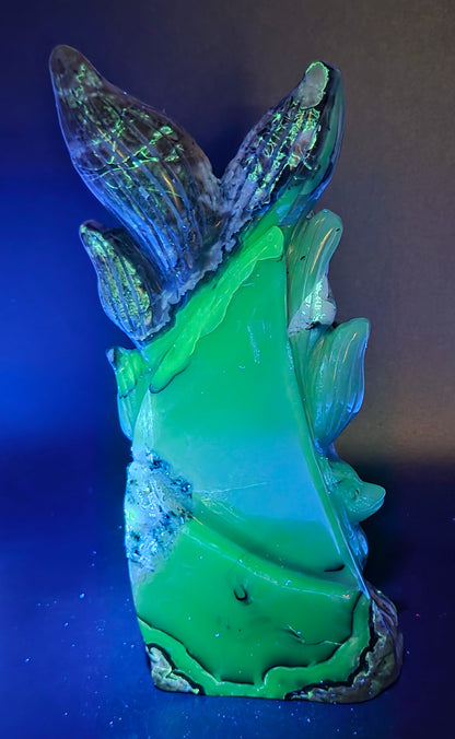 Volcano Agate carving of a nine tail fox under UV light against a black background