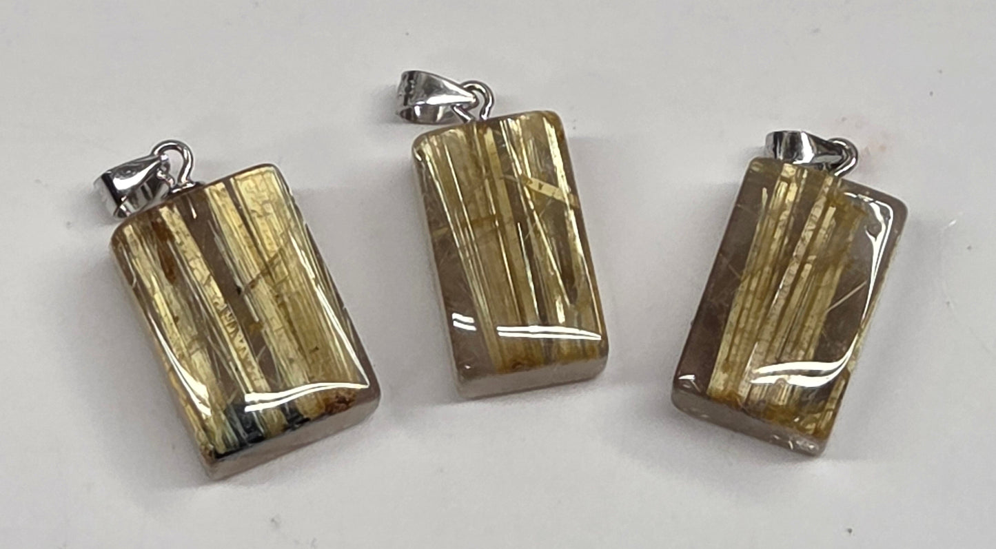 Three polished rectangular pendants with silver-toned bail loops, featuring a metallic gold and silver striped pattern, displayed on a light gray surface.